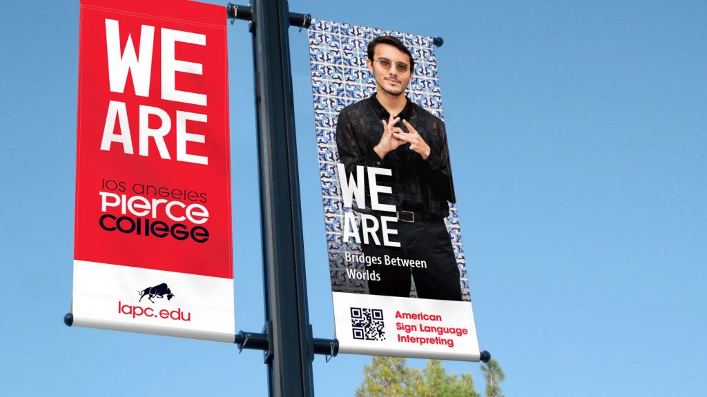 We Ar Campaign banners hanging from light pole showing a man folding his hands.
